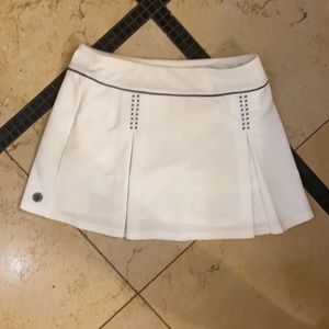 Tori Sport white tennis skirt with navy blue piping. Size medium.